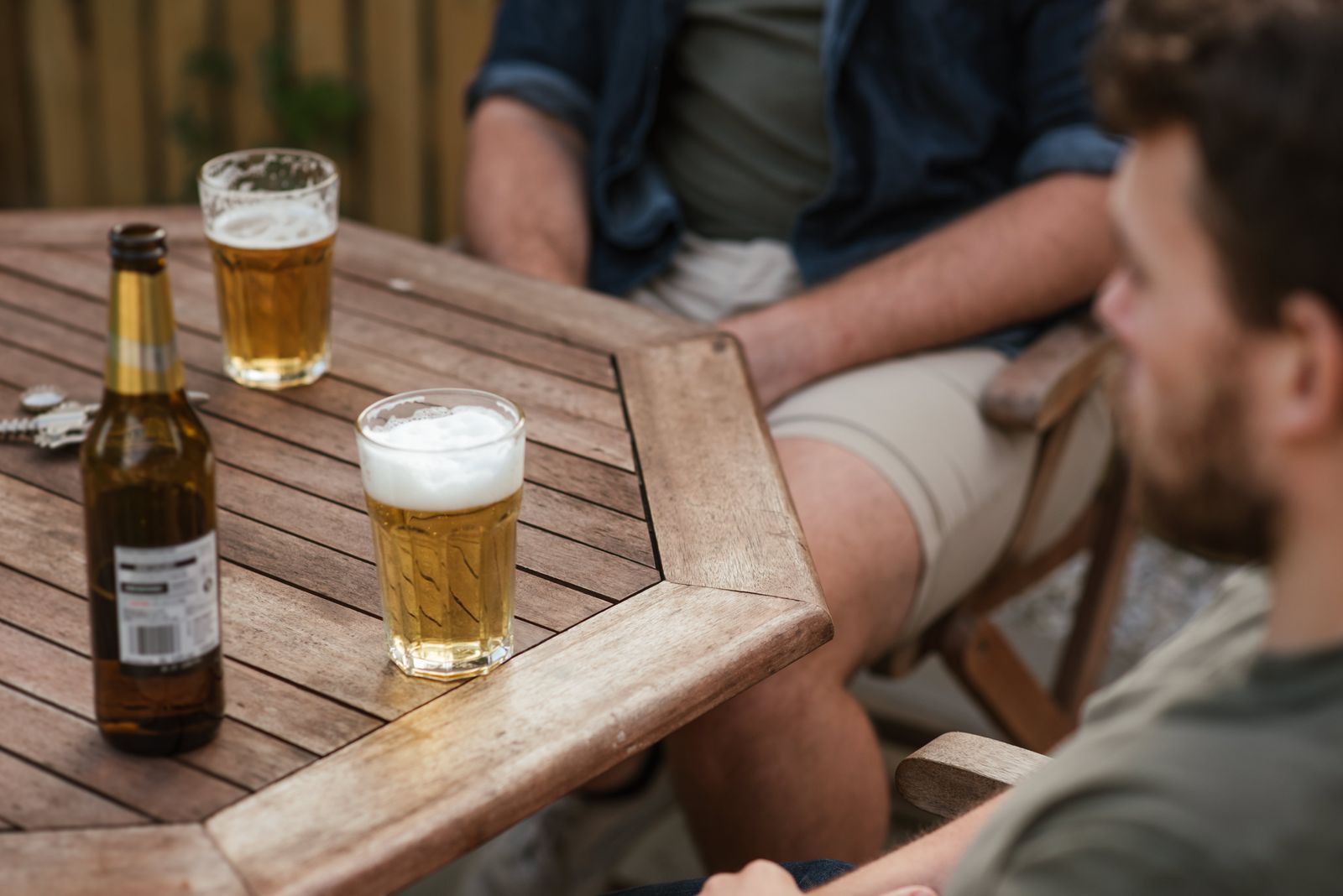 Samen aan de houten tuintafel in de avondzon